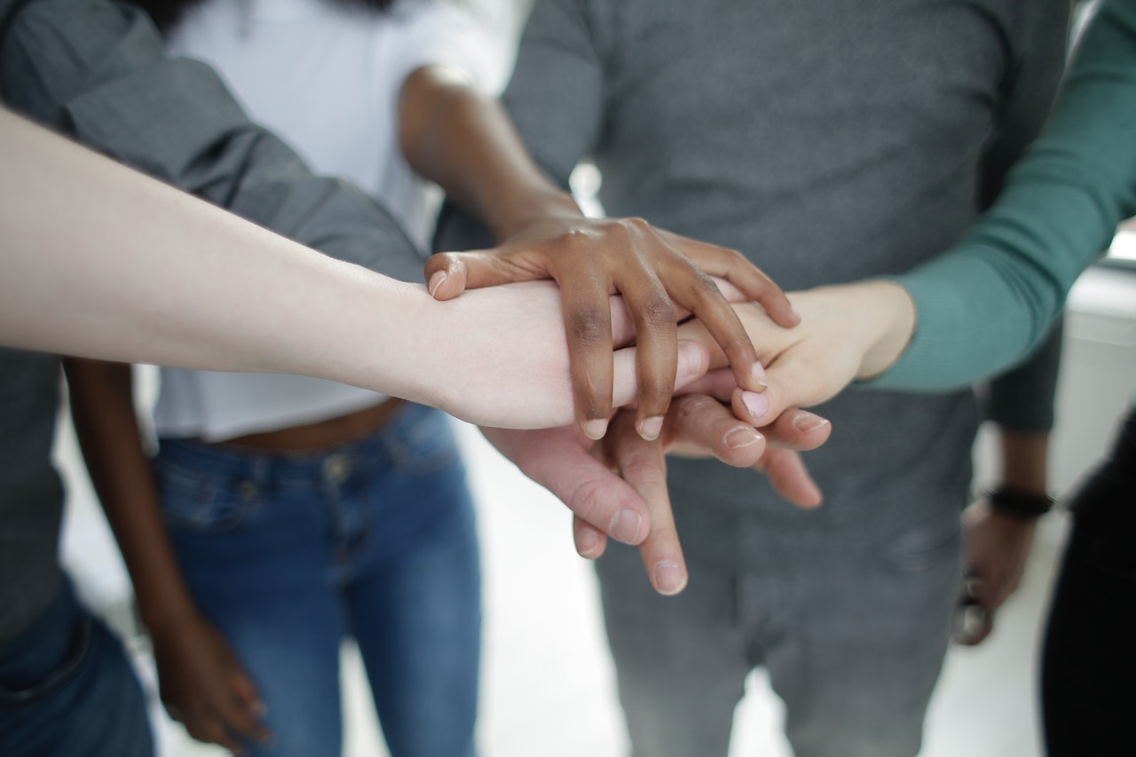 crop-diverse-colleagues-stacking-hands-together-during-3931607 le coaching d'équipe en entreprise développe la confiance